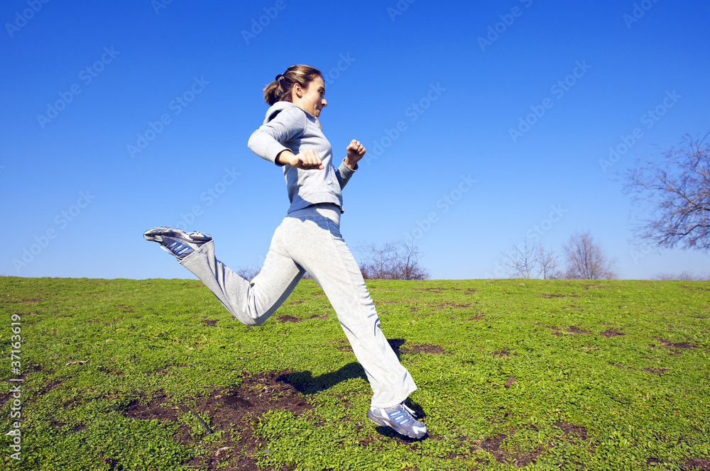 young girl jumping in autumn park