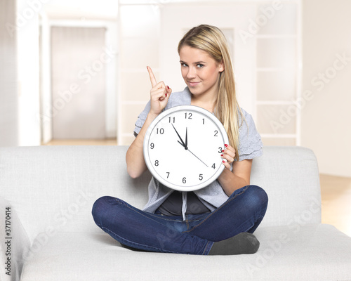 it's 5 before 12 - young woman pointing on clock / time photo