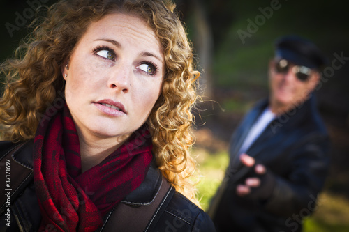 Pretty Young Teen Girl with Man Lurking Behind Her photo