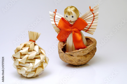 Angel made of straws standing in a walnut shell found a bag