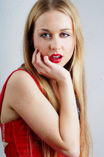 sexy blond woman in a red dress - studio portrait