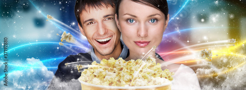 Portrait of young stylish modern couple watching movie at cinema