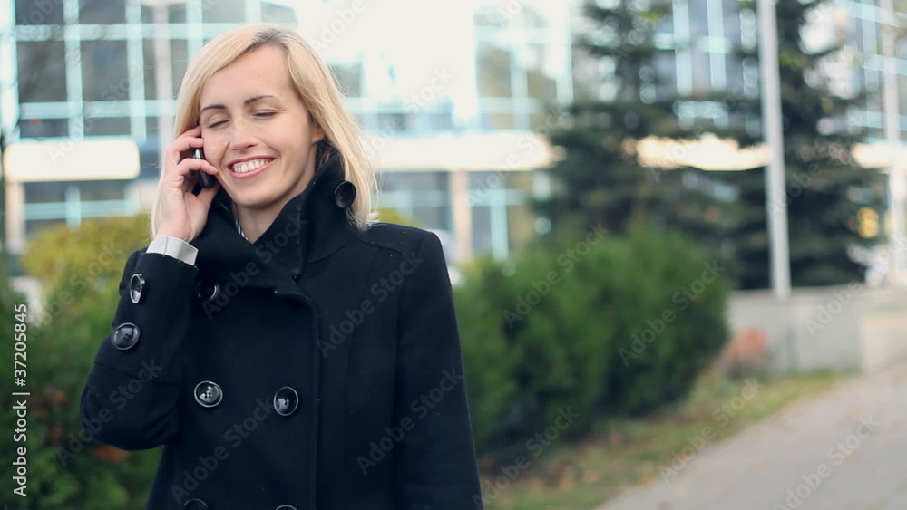 Happy woman in the city talking on mobile phone Happy woman in the city talking on mobile phone
