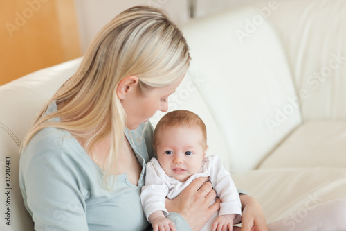 Mother on the sofa with her newborn on her lap