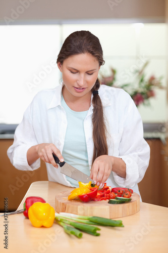 Portrait of a young woman slicing a pepper