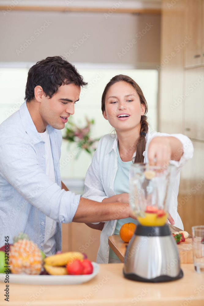 Portrait of a couple making fresh fruits juice Portrait of a couple making fresh fruits juice