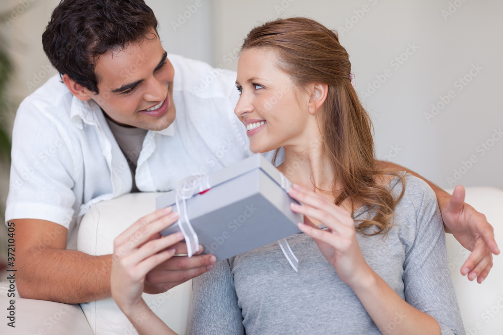 Woman smiling happily about the present she just got from her bo Woman smiling happily about the present she just got from her bo