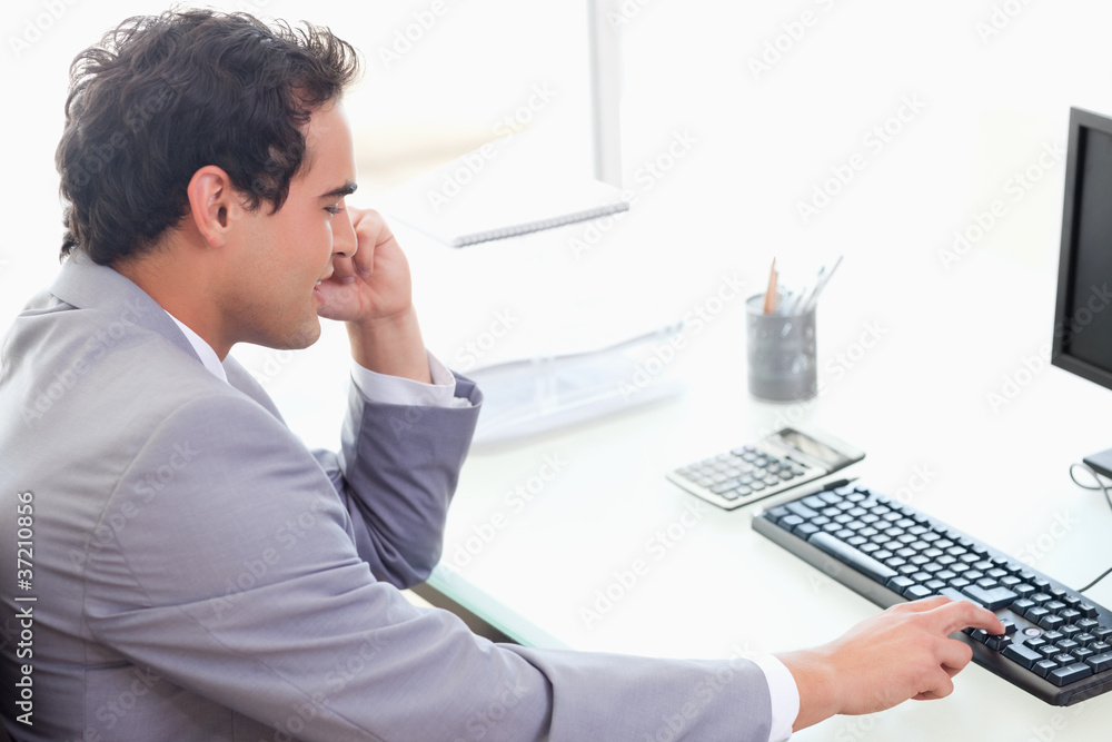 Naklejka premium Side view of businessman typing on his keyboard