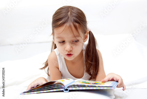 Bilde på lerret sweet little girl reading a book