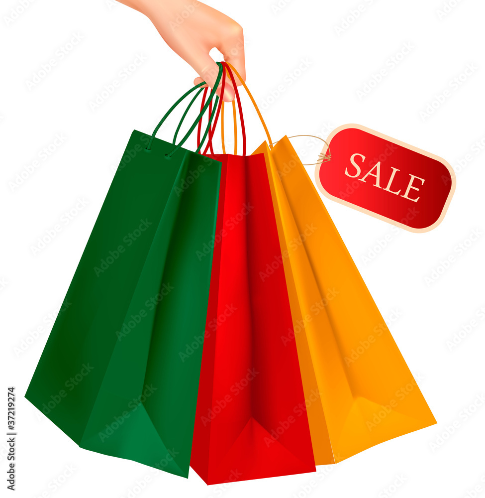 Hand holding colorful shopping bags with sale tag.