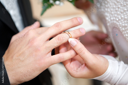 Newly-married couple on wedding dresses gold rings