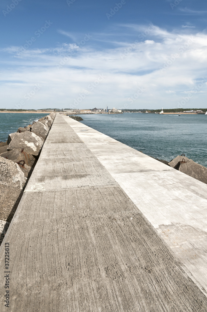 Long concrete jetty with sea and blue sky