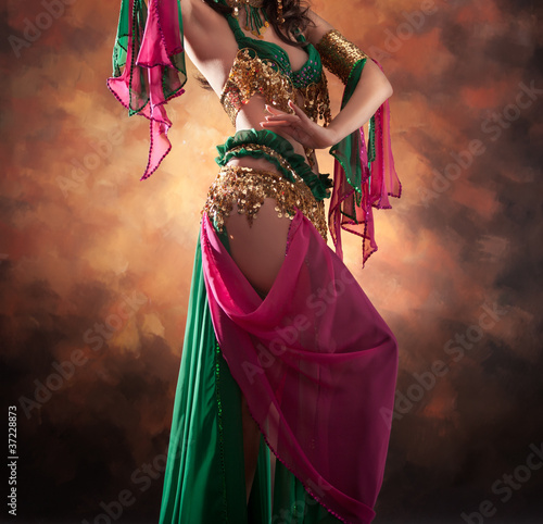 Beautiful exotic belly dancer woman a rot-green costume