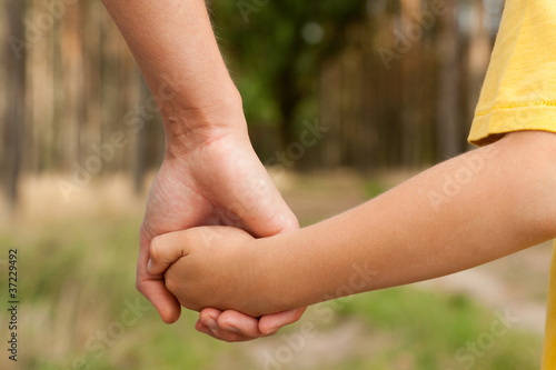 Mother holding a hand of his son