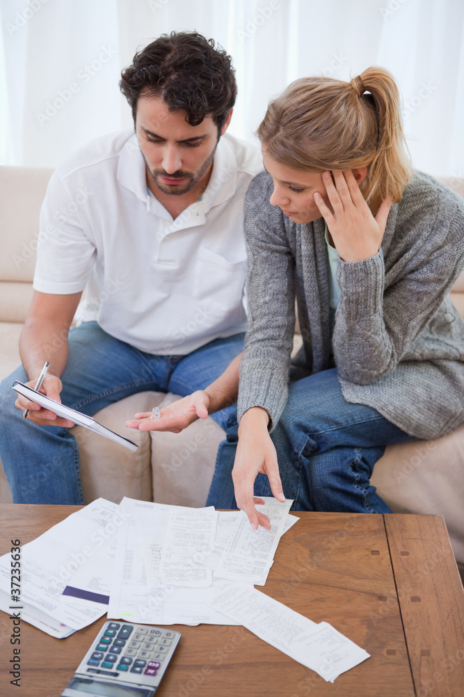 Portrait of a worried couple looking at their bills Portrait of a worried couple looking at their bills