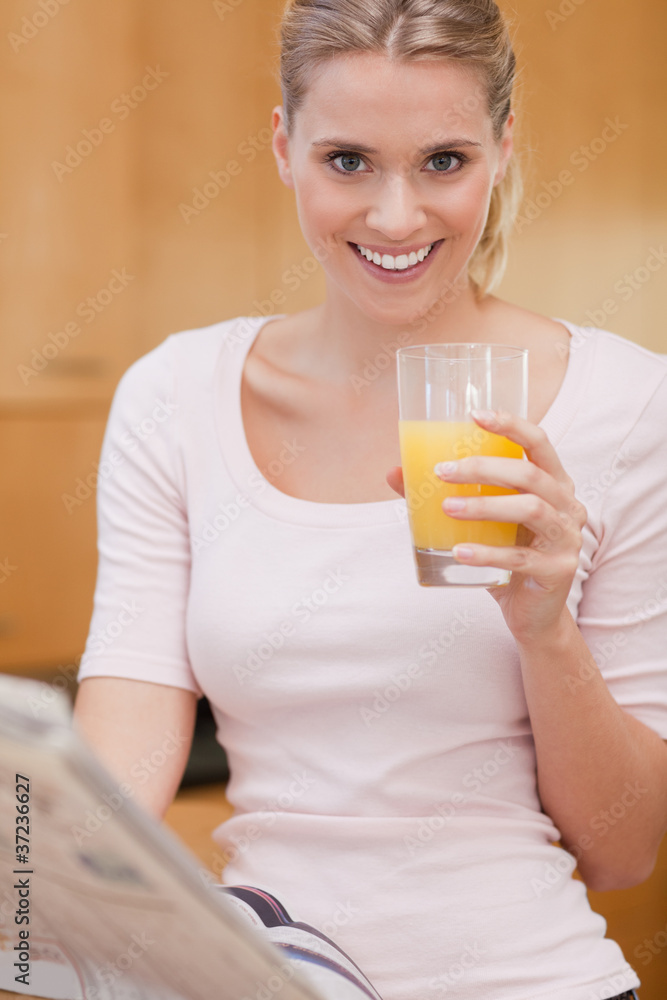 Portrait of a cute woman reading the news while drinking juice Portrait of a cute woman reading the news while drinking juice