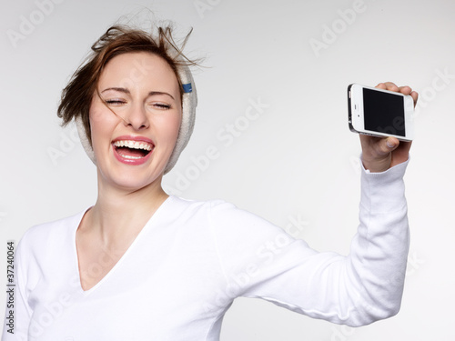 Laughing girl takes a self-photograph with smart phone