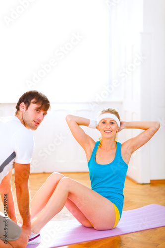 Smiling fit girl making abdominal crunch