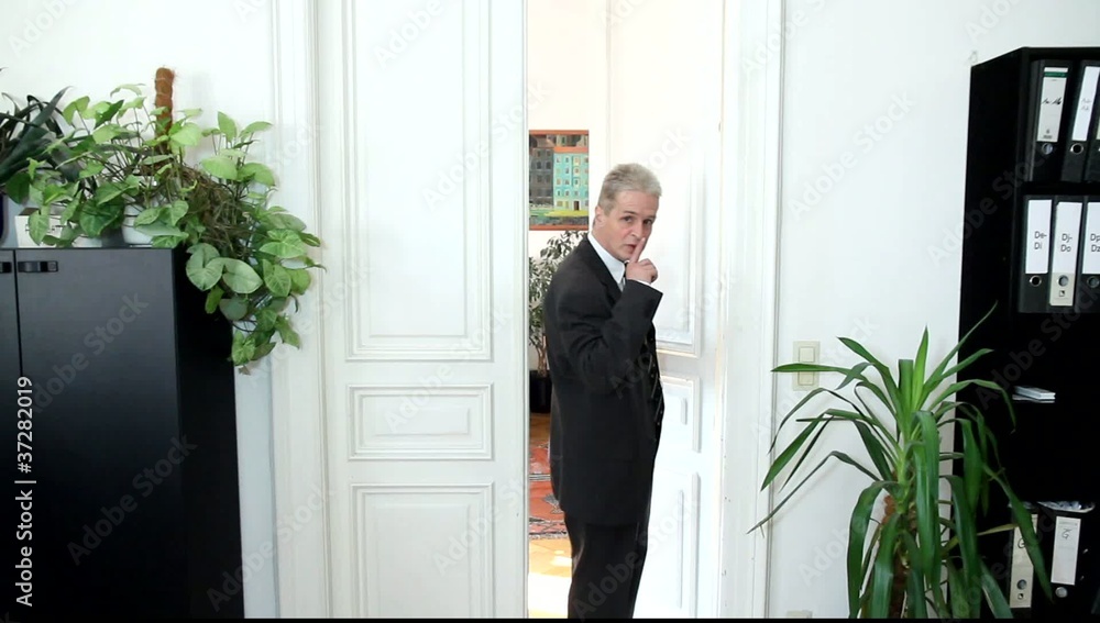 Ein Mann in einem Büro fordert zum Schweigen auf Ein Mann in einem Büro fordert zum Schweigen auf