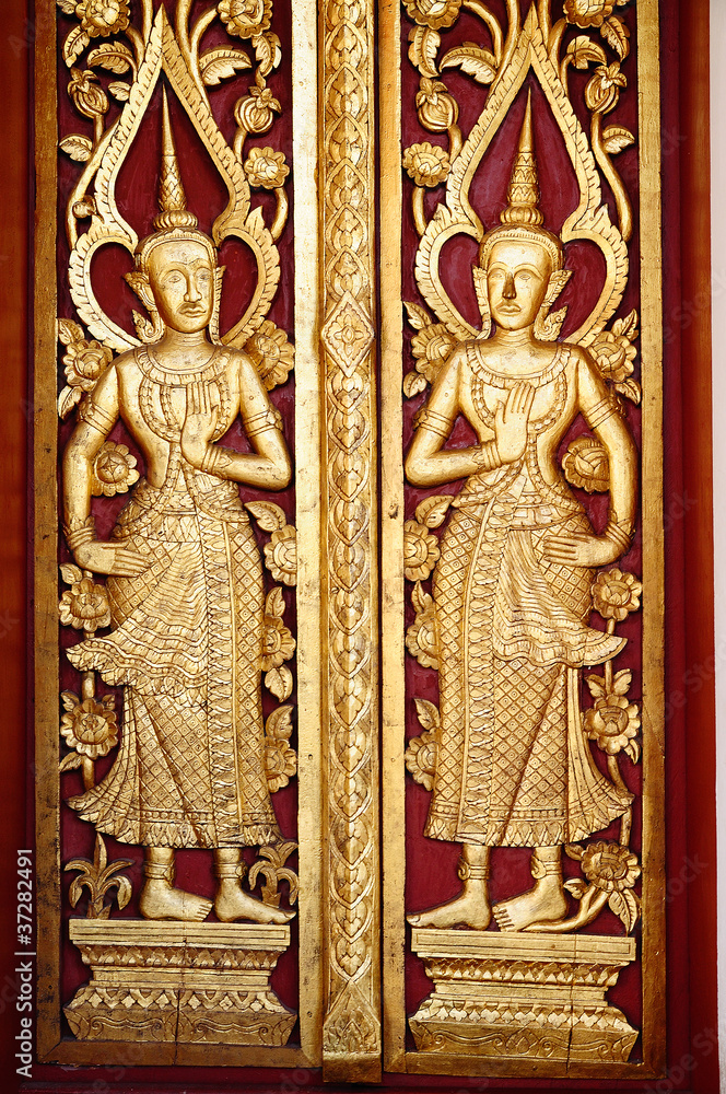 Ancient northern thai art of wood carving on wooden door.