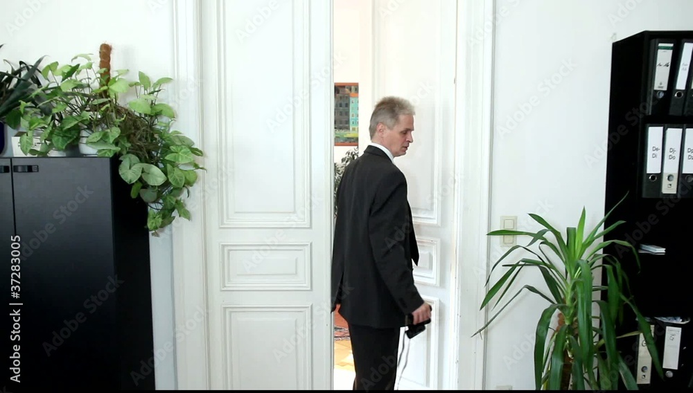 Ein Mann steht suchend mit einem Ferglas vor einer Bürotüre Ein Mann steht suchend mit einem Ferglas vor einer Bürotüre