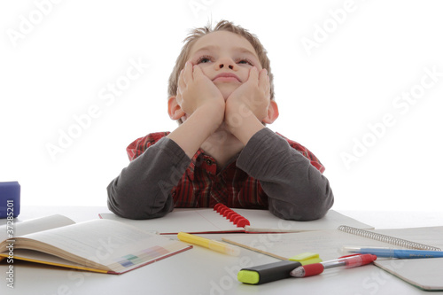 Photos enfant graçon rêvant au lieu de faire ses devoirs