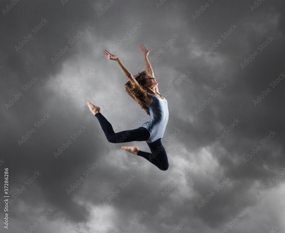 A young Caucasian female dancer caught in a jump