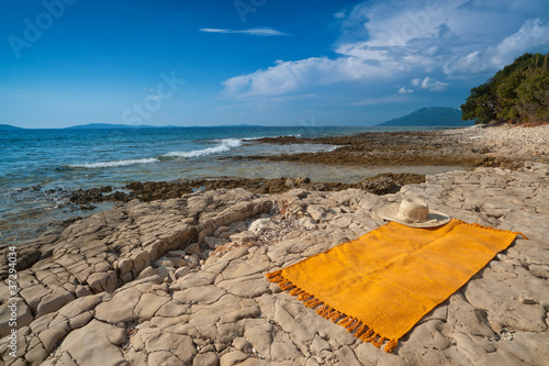 Wild Adriatic sea beach with rug for tanning. Croatia, Losinj photo