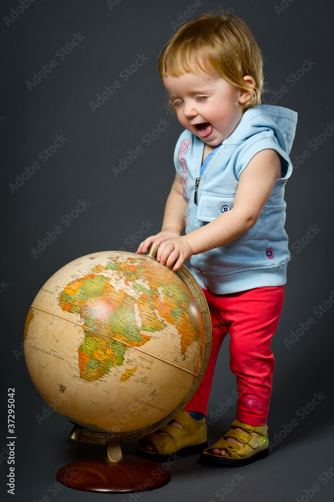 Cute little baby with globe isolated on grey Cute little baby with globe isolated on grey