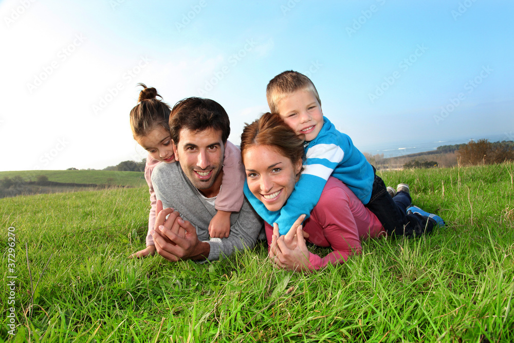 Portrait of happy family laying in country field Portrait of happy family laying in country field