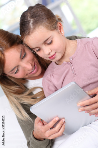 Mother and child using electronic tablet at home