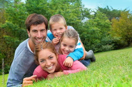 Portrait of happy family laying in country field