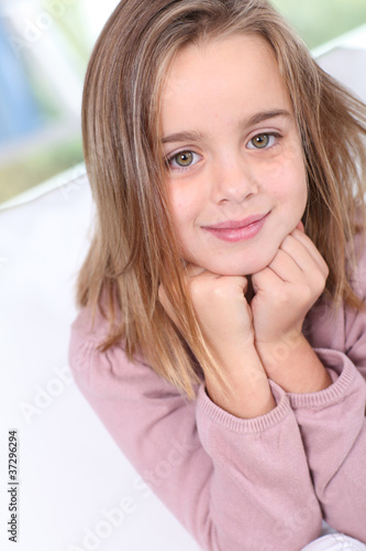Portrait of cute little girl with hands on chin