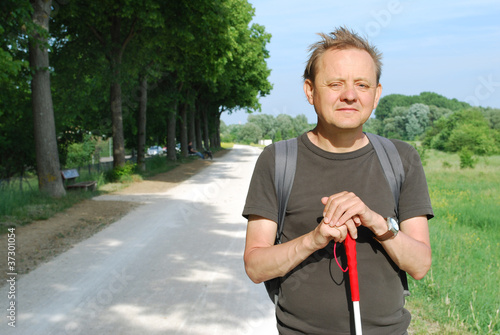 Blinder Mann mit Blindenstock unterwegs im Freien