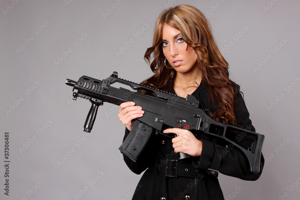 Beautiful girl holding an automatic rifle.