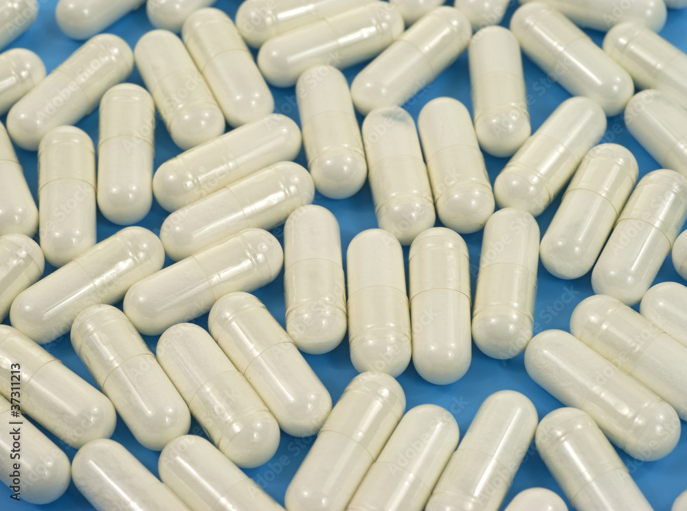 Acidophilus capsules on blue background Acidophilus capsules on blue background