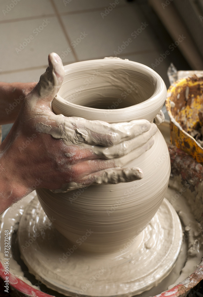 hands of a potter, creating an earthen jar on the circle hands of a potter, creating an earthen jar on the circle