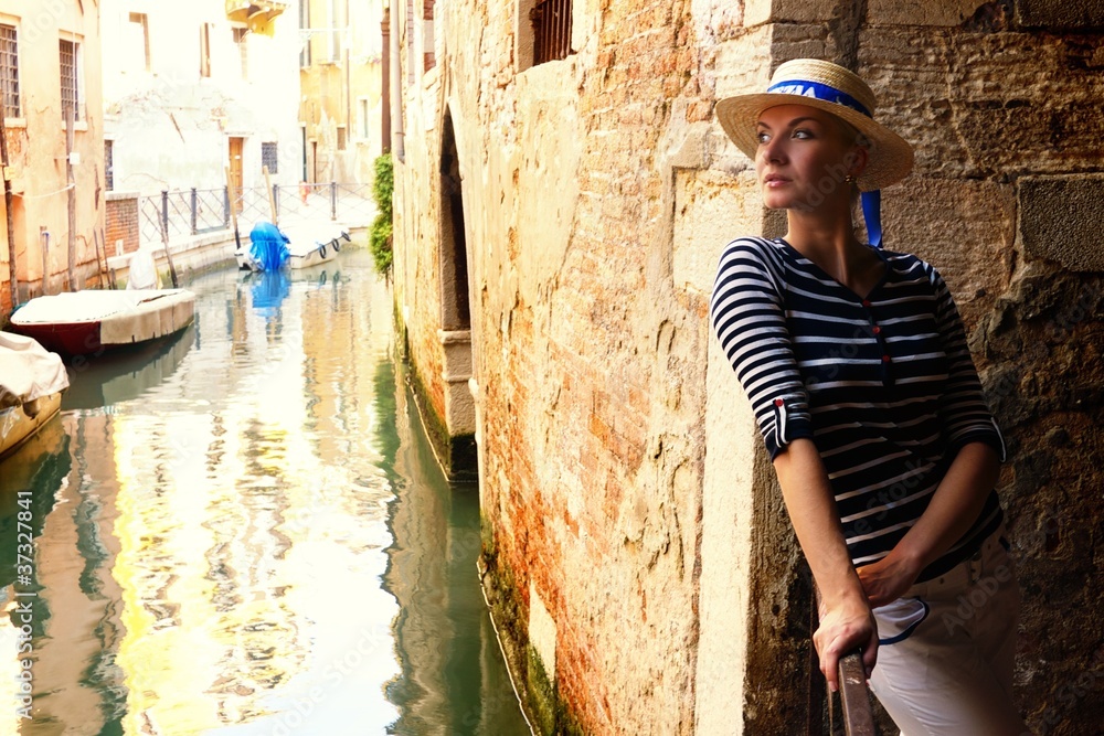 Woman against venetian canal.