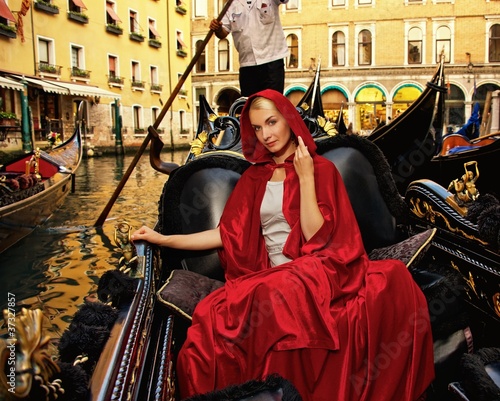 Beautifiul woman in red cloak riding on gandola © Nejron Photo