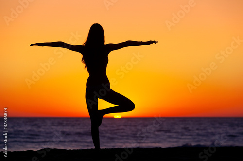 Silhouette of a beautiful Yoga woman at Sunset