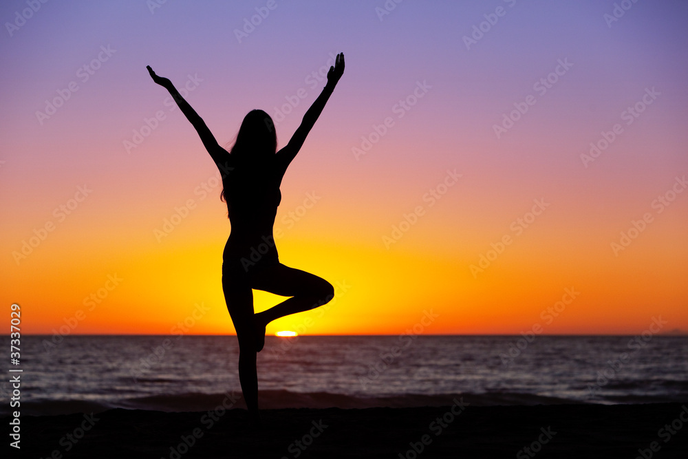 Silhouette of a beautiful Yoga woman at Sunset