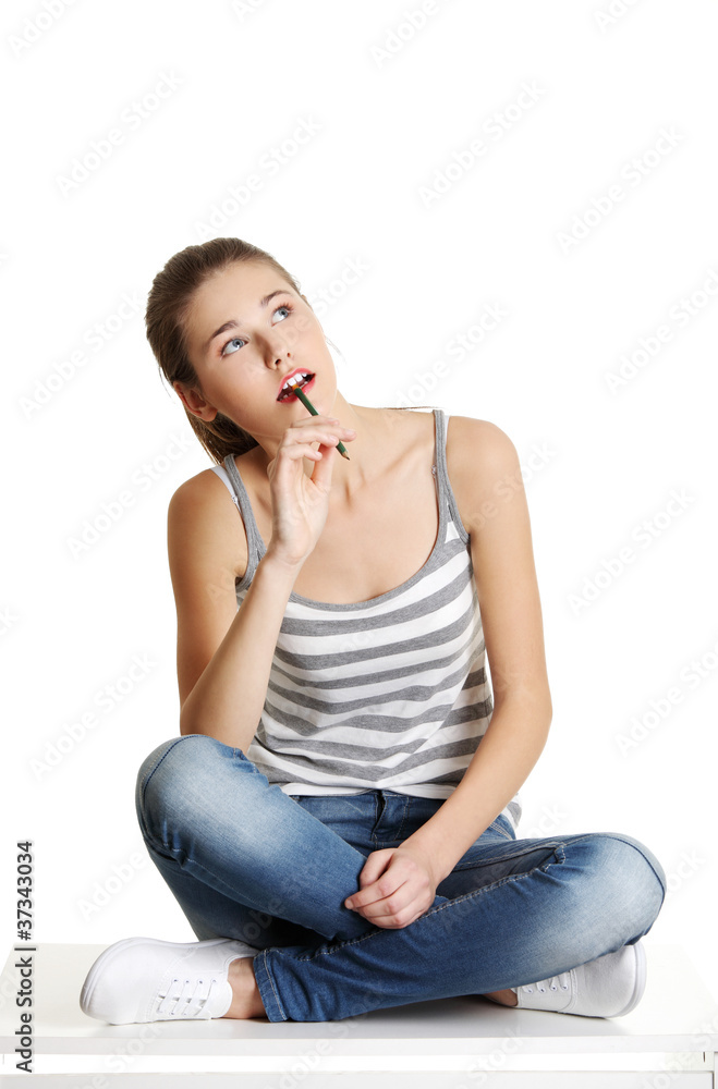 Thoughtfull female teen sitting on a table. Thoughtfull female teen sitting on a table.