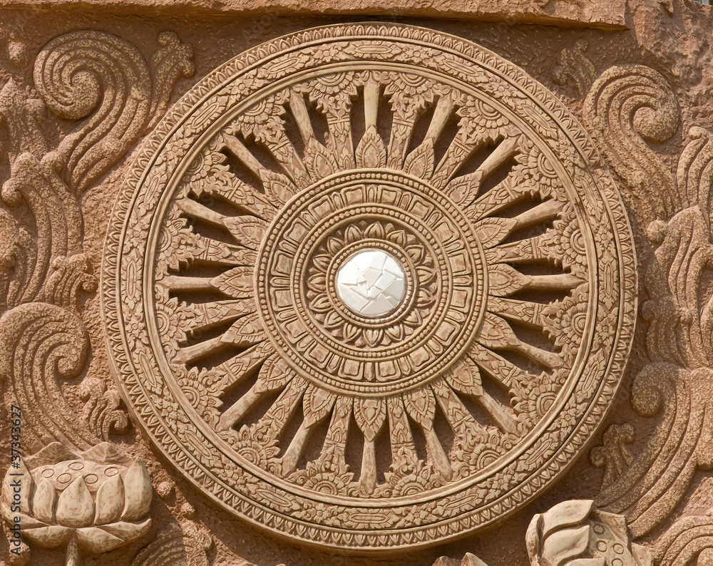 carving on stone the wheel of law symbol of buddhism