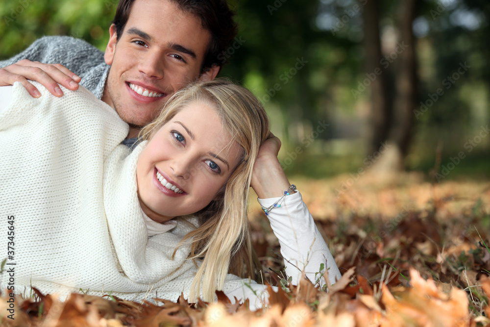 Young couple lying on the grass together Young couple lying on the grass together