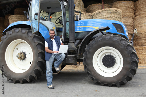 Farmer using a laptop on his tractor