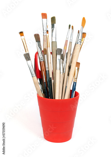 paint brushes in red glass