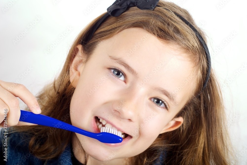 Girl brushing teeth on white background Girl brushing teeth on white background