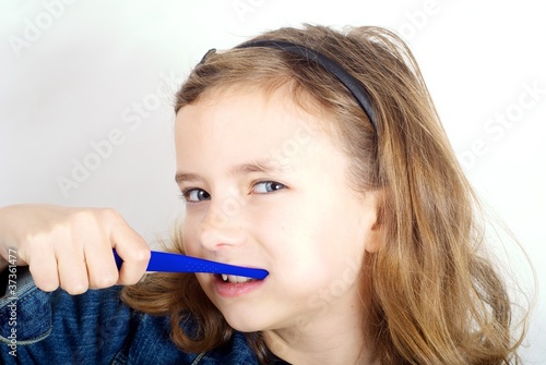 Girl brushing teeth on white background