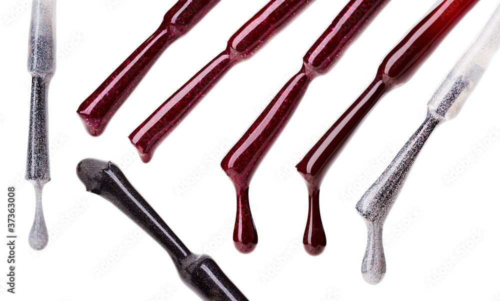 Set of multicolored nail polish brushes and drops isolated on wh Set of multicolored nail polish brushes and drops isolated on wh