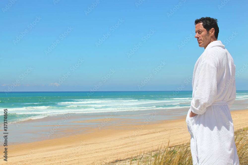 Man on the beach in towelling robe